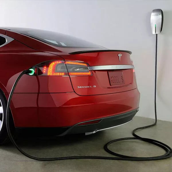 Tesla wall connector installed on a red Model S
